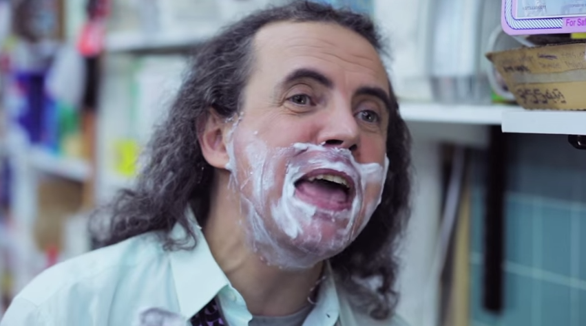Image of a man with long hair and shaving cream on his face