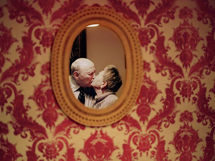 Image of a couple kissing reflection through a mirror
