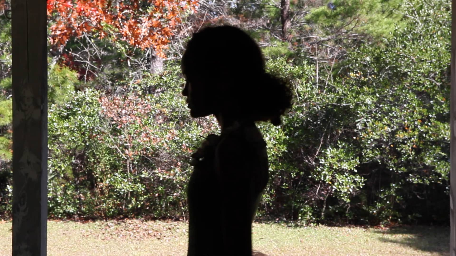 Silhouette image of a girl side profile standing in a garden