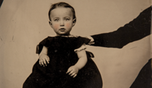 Sepia image of little gir with a hand on her shoulder