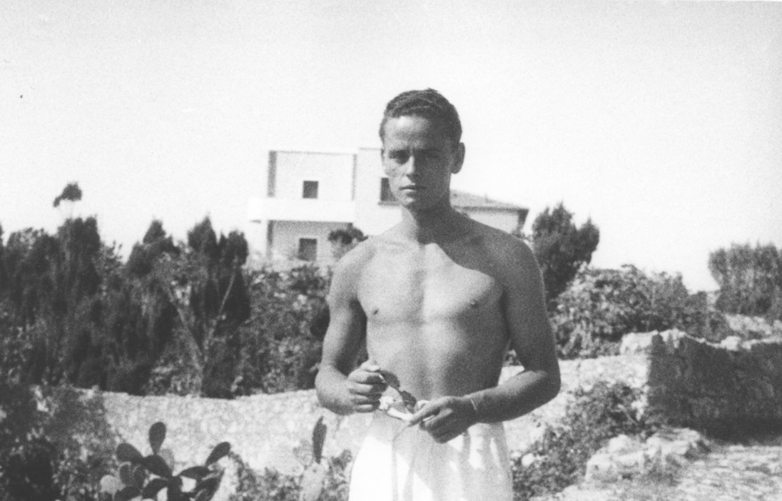Young man shirtless on the beach. Black and white photo