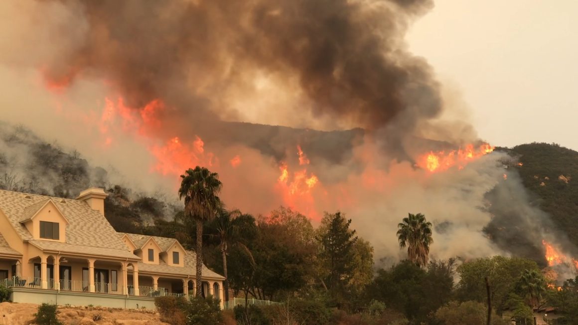 Forest fires seen in the hills of Los Angeles, above a mansion