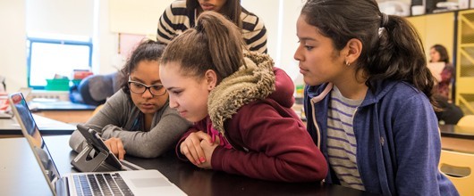 Three female students looking at an iPad