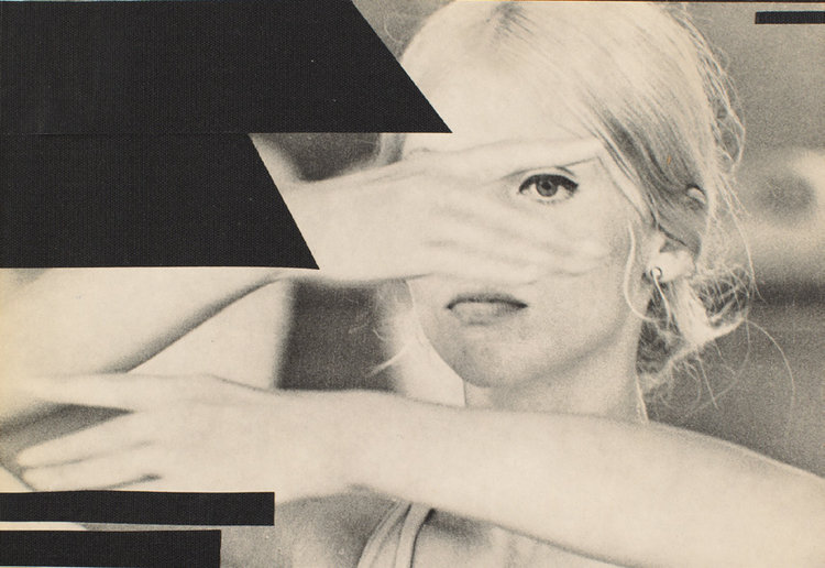 A blond woman with a hand in front of her face peers through her split fingers