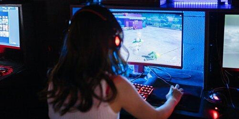 A Woman playing video games on a computer