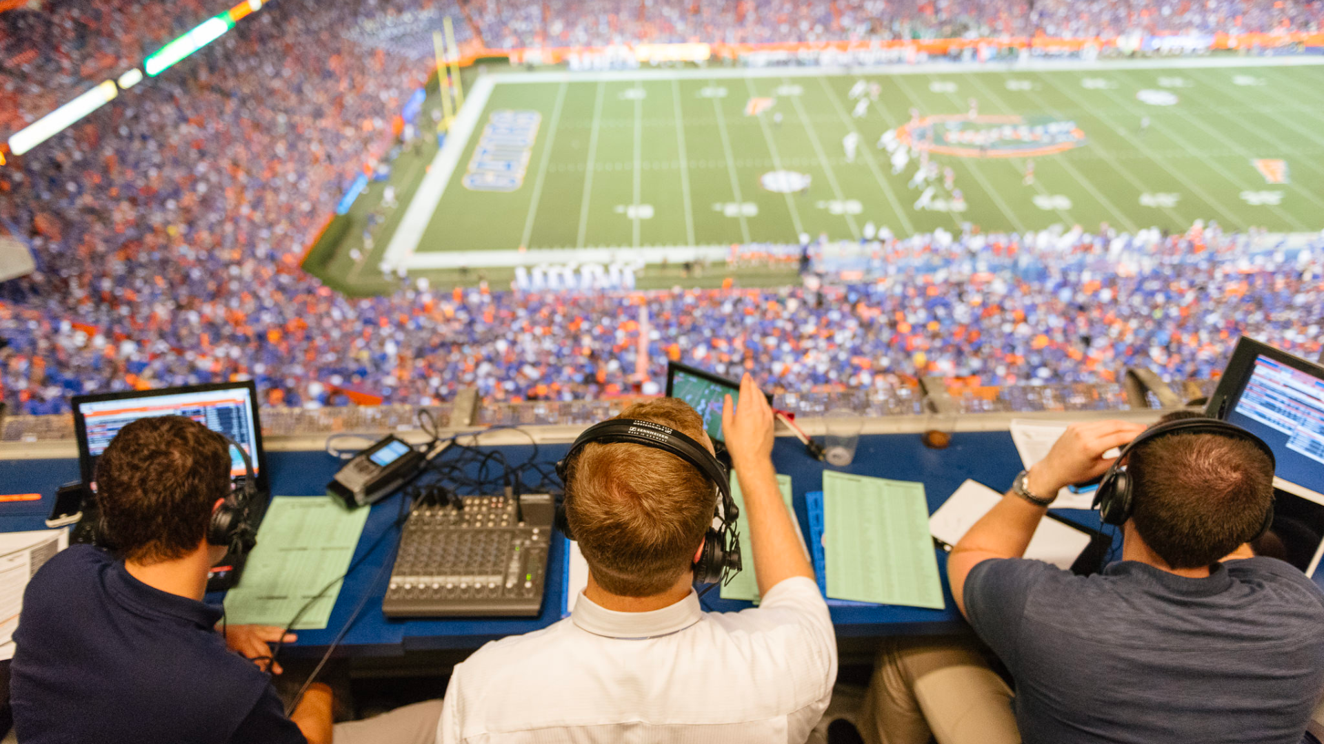 game announced and tech crew sit and work at a stadium fill of people